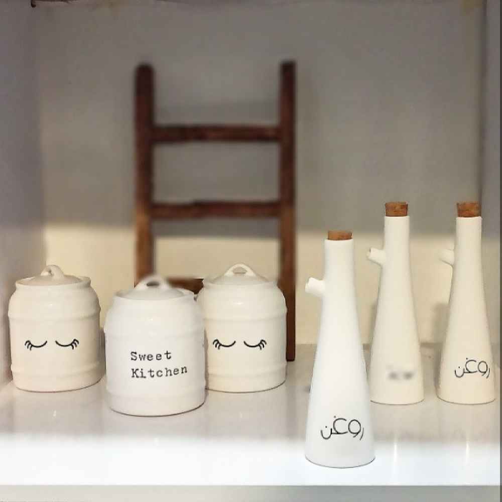 زجاجة توزيع زيت بورسلين بيضاء لوضعها على الطاولة للطهي في المطبخ