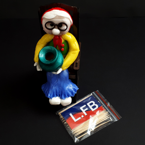 حامل أسنان خشبي بتصميم امرأة مسنّة على كرسي