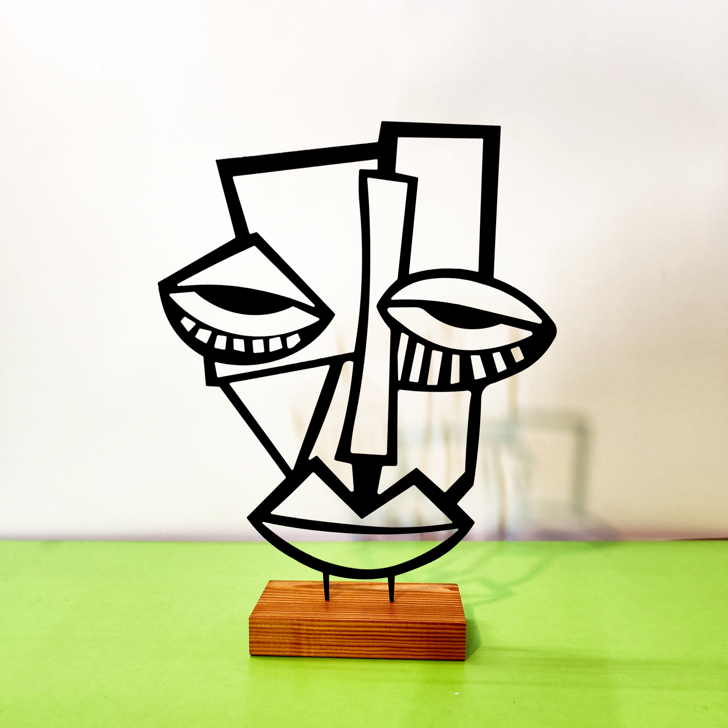 تمثال فني بسيط لوجه بأسلوب التكعيبية مصنوع من المعدن