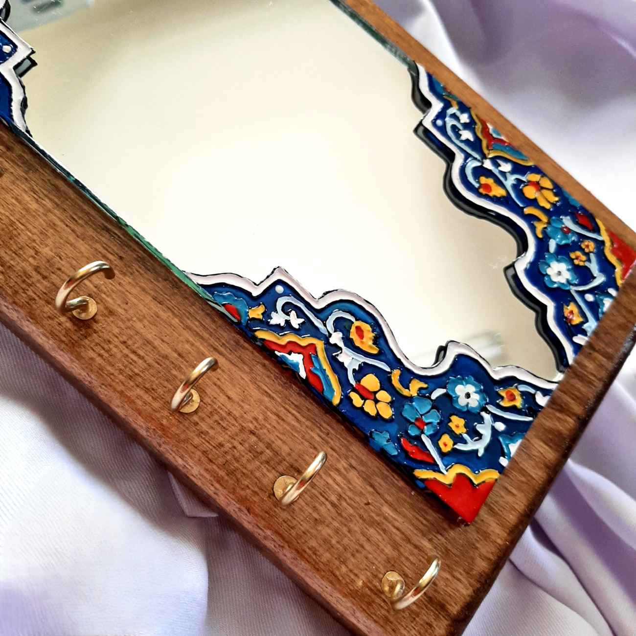 مرآة معلقة على الحائط مع حامل مفاتيح ورسمة زجاجية بارزة