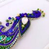 دبوس الطاووس المرصع – لمسة من الجمال البري